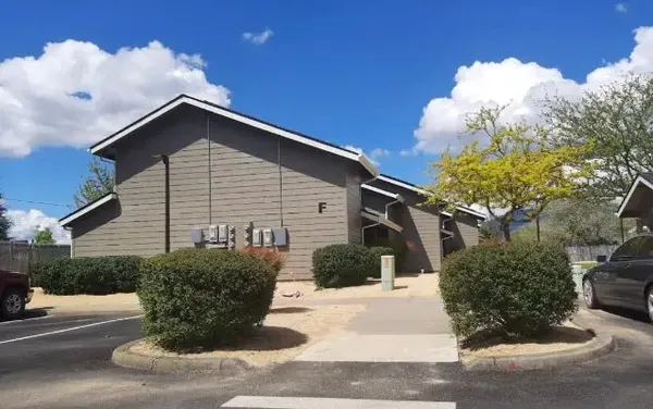 a white house with a flower garden in front of it