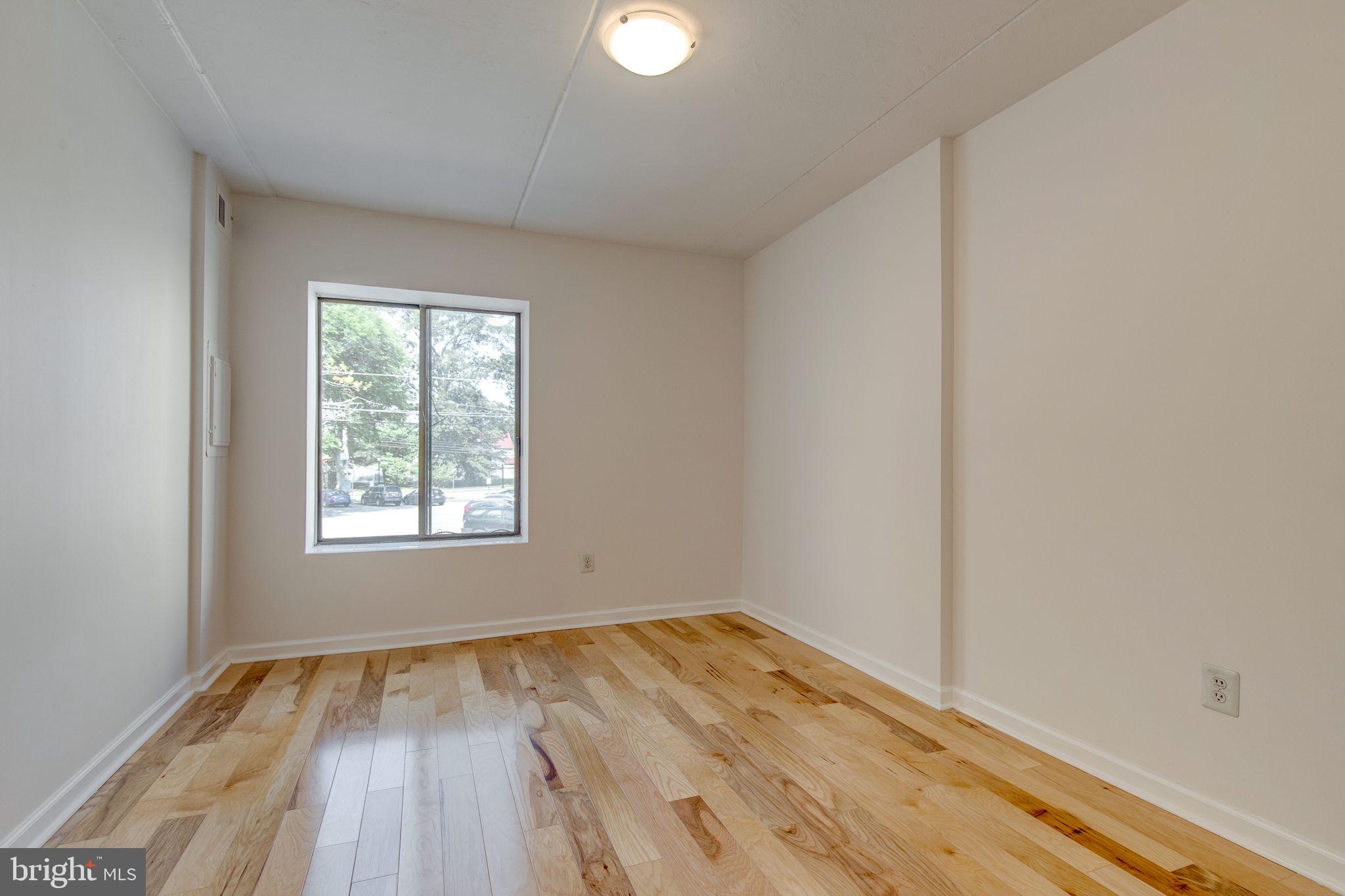 100 Rutgers Avenue, Unit 8 Swarthmore, PA 19081 - Photo 11 of 29 an empty room with wooden floor and windows