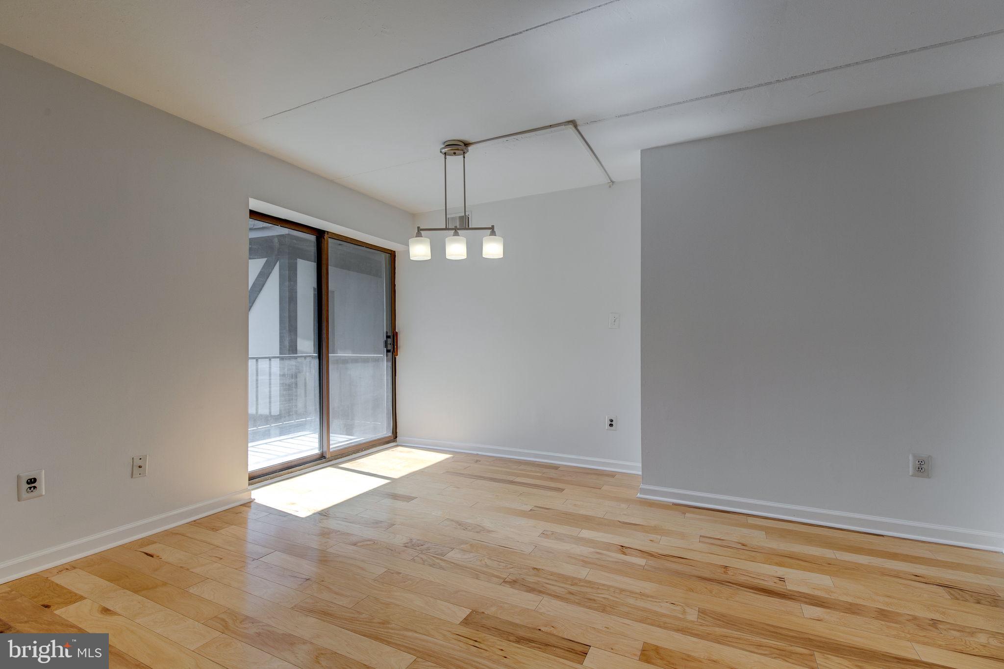100 Rutgers Avenue, Unit 8 Swarthmore, PA 19081 - Photo 13 of 29 an empty room with wooden floor and chandelier