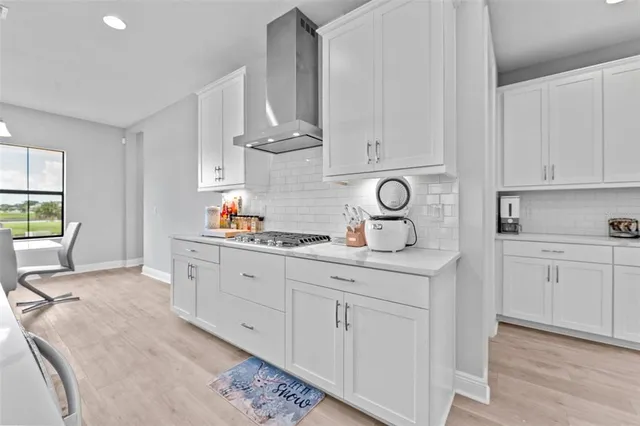 a kitchen with white cabinets and sink