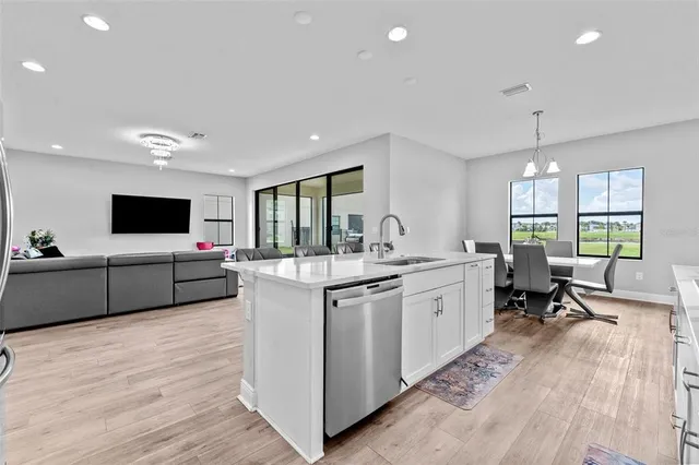 a large kitchen with kitchen island a sink a counter top space and stainless steel appliances