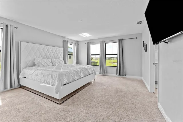 a bedroom with a large bed and a flat screen tv