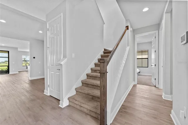 a view of a hallway with wooden floor and entryway