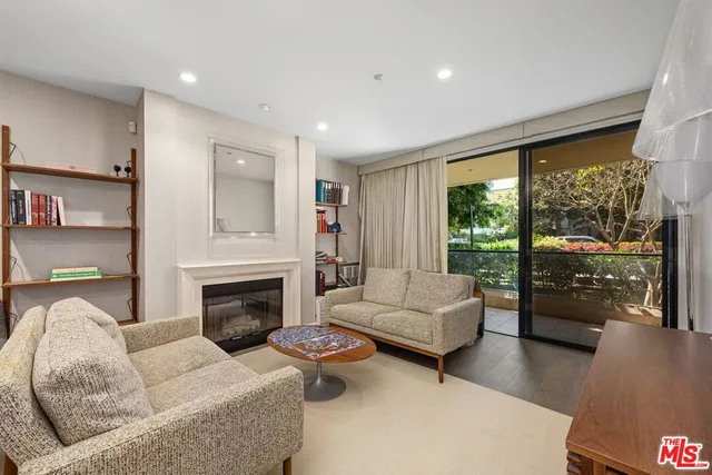 a living room with furniture fireplace and a large window