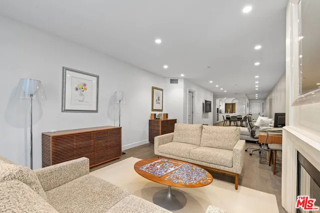 a living room with furniture and a view of kitchen