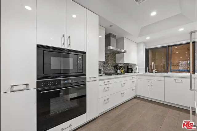 a kitchen with stainless steel appliances white cabinets and stove