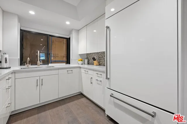 a kitchen with white cabinets and sink