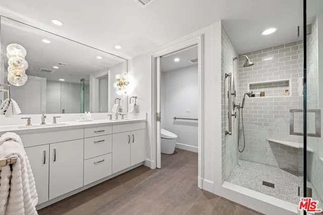 a bathroom with a double vanity sink mirror and shower