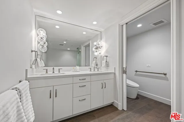 a bathroom with a granite countertop sink a toilet and a mirror