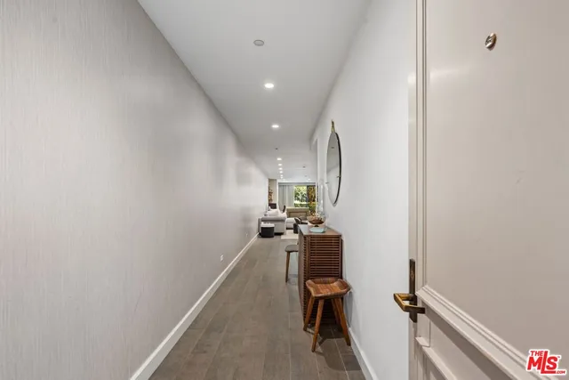 a view of a hallway with workspace and wooden floor