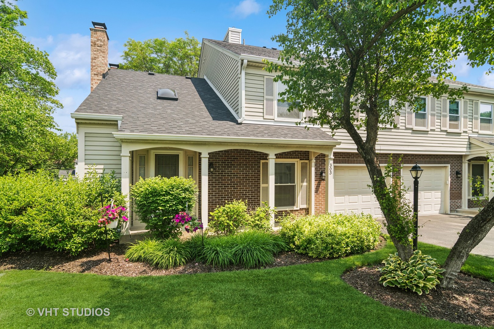 a front view of a house with a yard and potted plants