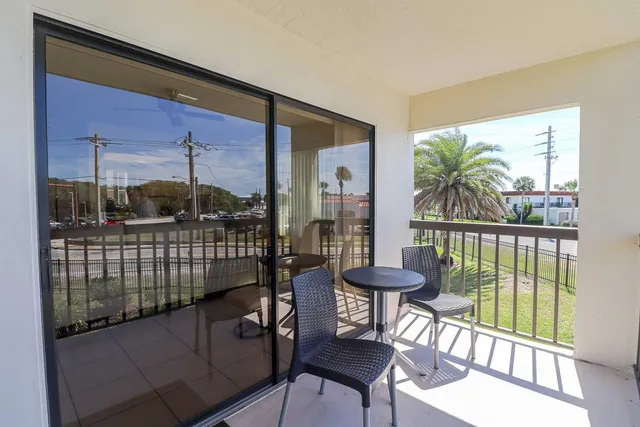 a balcony with chairs and a table