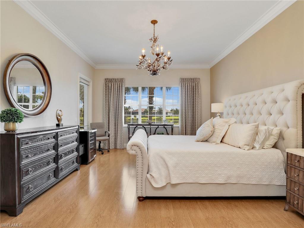 2718 Callista Court, Unit 101 Naples, FL 34114 - Photo 12 of 34 a bedroom with a bed and a chandelier