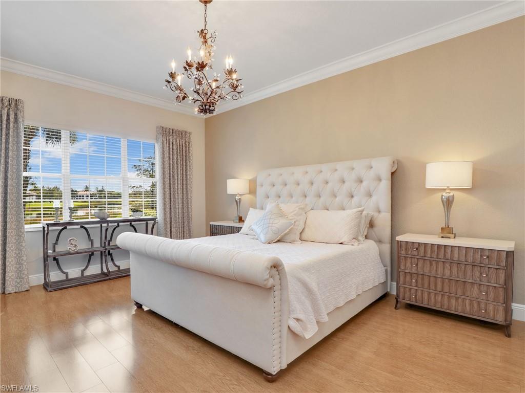 2718 Callista Court, Unit 101 Naples, FL 34114 - Photo 13 of 34 a bedroom with a bed and a chandelier