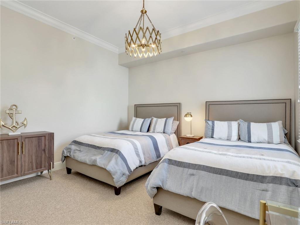 2718 Callista Court, Unit 101 Naples, FL 34114 - Photo 17 of 34 a bedroom with two beds and a chandelier