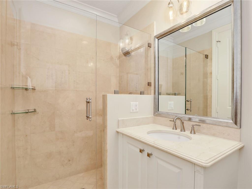 2718 Callista Court, Unit 101 Naples, FL 34114 - Photo 18 of 34 a bathroom with a sink and a mirror