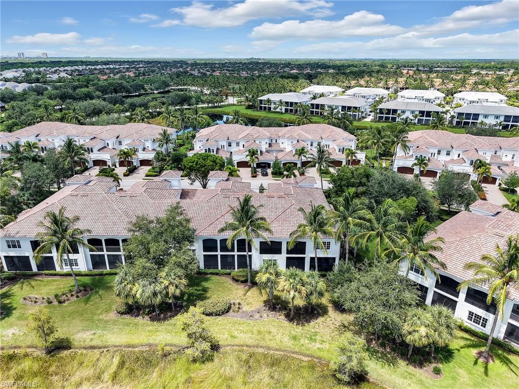 2718 Callista Court, Unit 101 Naples, FL 34114 - Photo 26 of 34 a view of a garden with lawn chairs and large trees