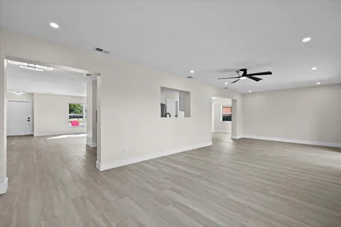 a view of a big room with wooden floor and windows