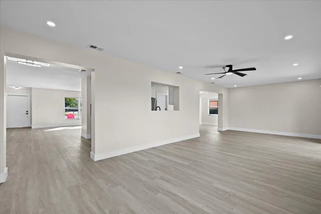 a view of a big room with wooden floor and windows