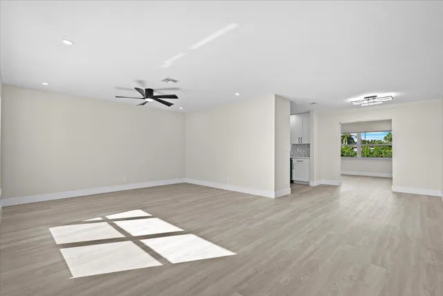 a view of empty room with wooden floor and ceiling fan