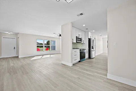 a kitchen with stainless steel appliances white cabinets and a stove top oven