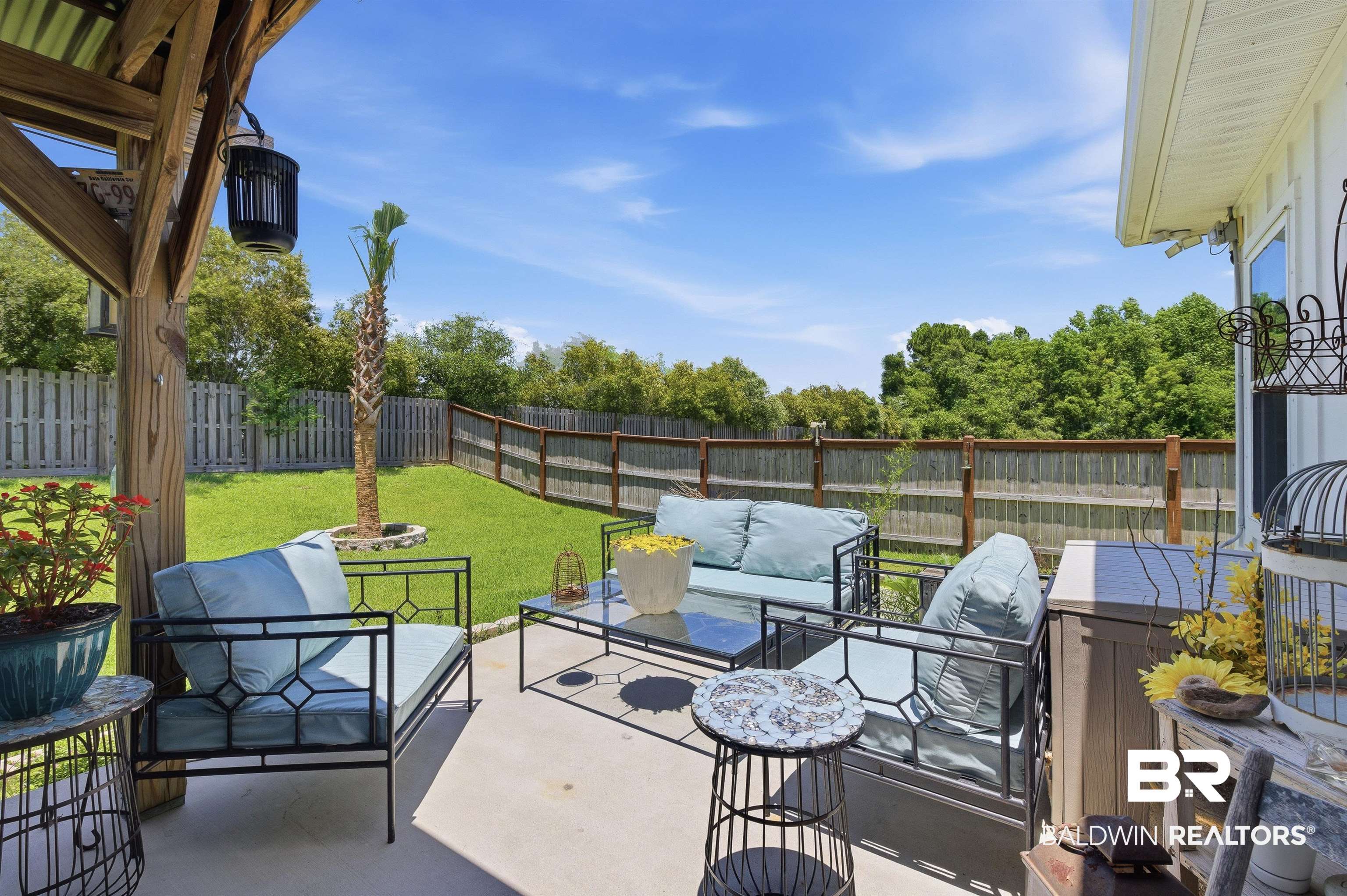 8735 Bronze Lane Foley, AL 36535 - Photo 43 of 58 Concrete patio with a wood-frame covered area, featuring a corrugated metal roof