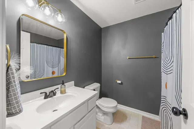 a bathroom with a sink a toilet and a mirror