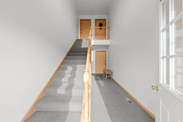 a view of a hallway with wooden floor and staircase