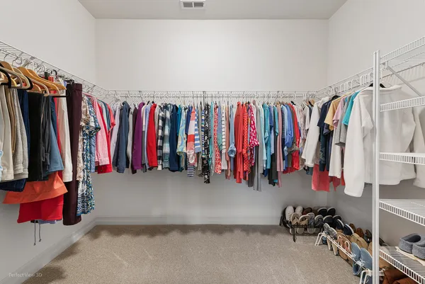 a view of walk in closet with clothes