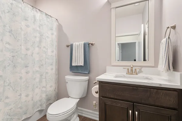 a bathroom with a granite countertop sink toilet and mirror