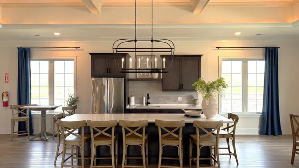 a kitchen with stainless steel appliances a dining table chairs and wooden floor
