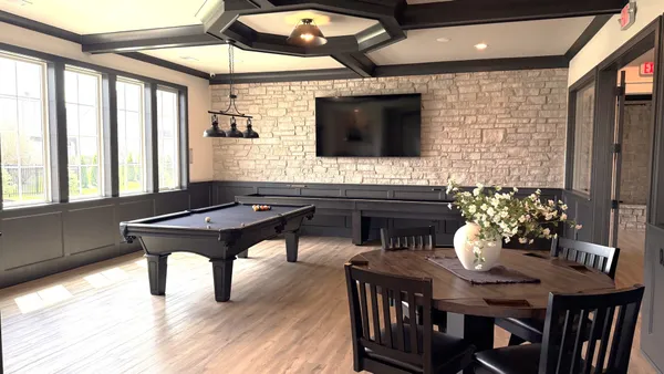 a living room with a table chairs and a flat screen tv