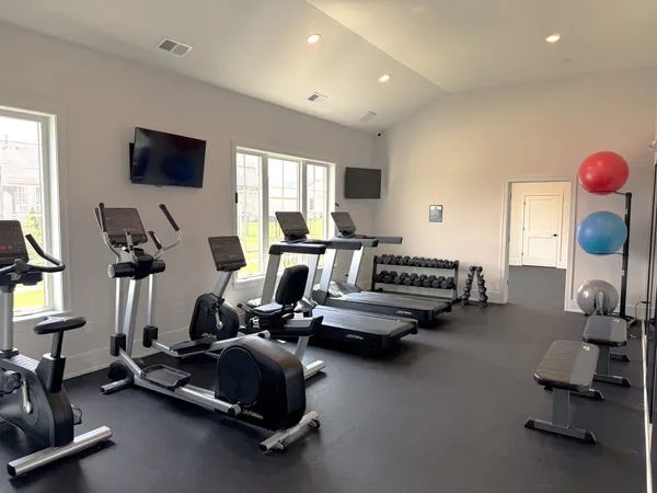 a room with gym equipment and a flat screen tv