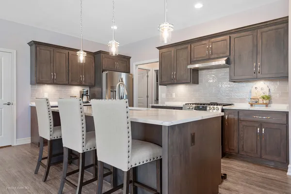 a kitchen with kitchen island granite countertop wooden cabinets and white appliances