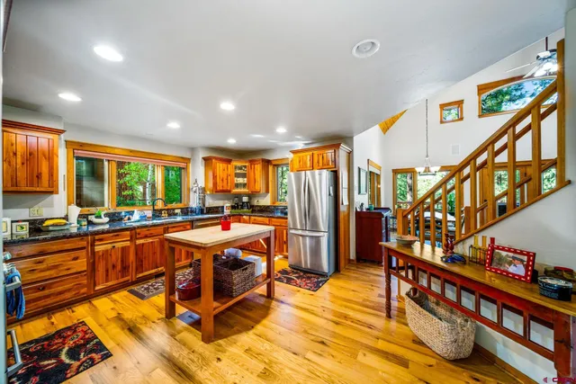 a very nice looking living room with stainless steel appliances lots of white furniture