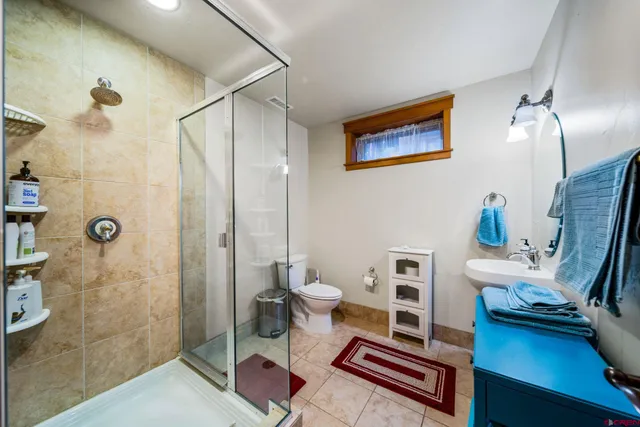 a bathroom with a sink a toilet and shower