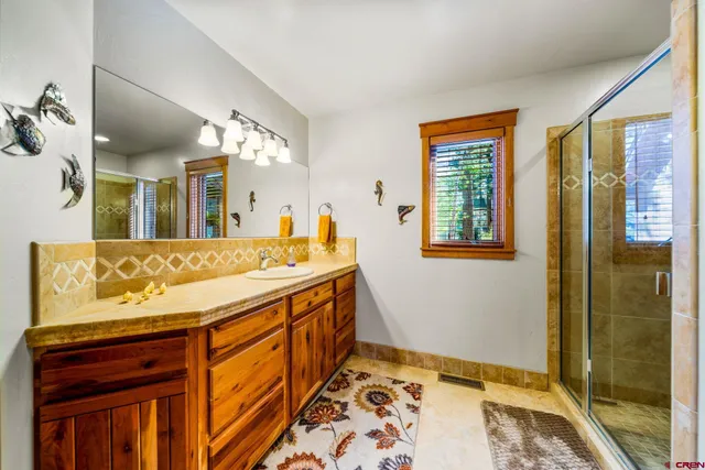 a bathroom with a sink a mirror and a shower