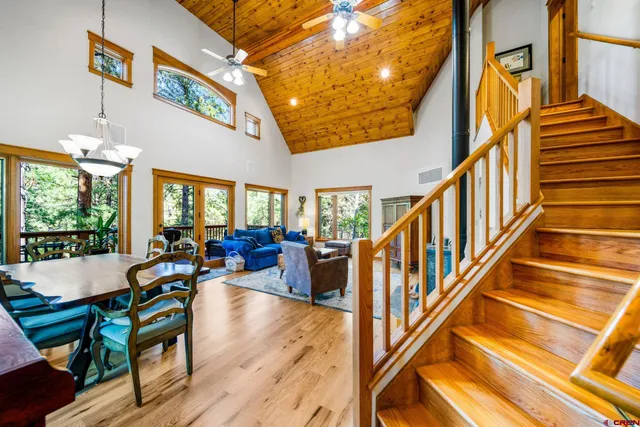 a view of a patio with couches potted plants and wooden floor