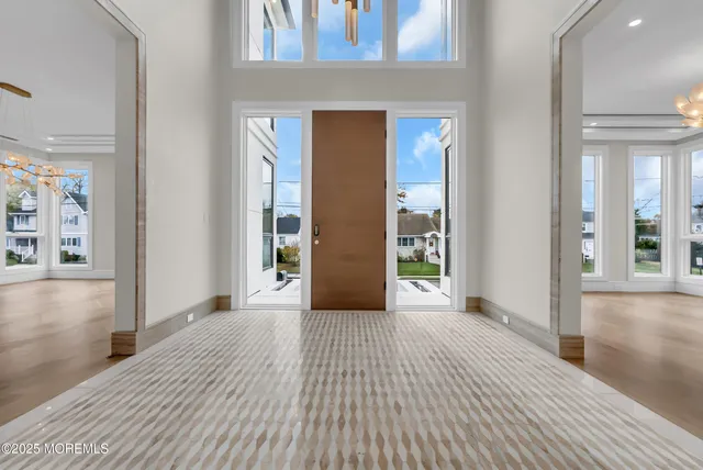 a view of a hallway with wooden floor and a living room