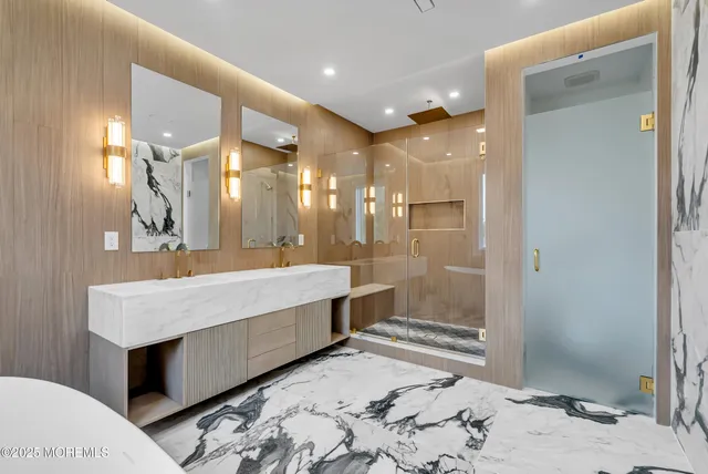 a bathroom with a sink a large mirror and a shower