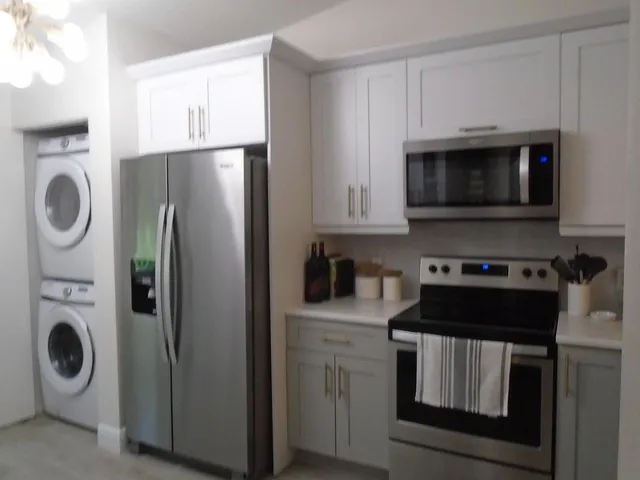a kitchen with white cabinets and stainless steel appliances