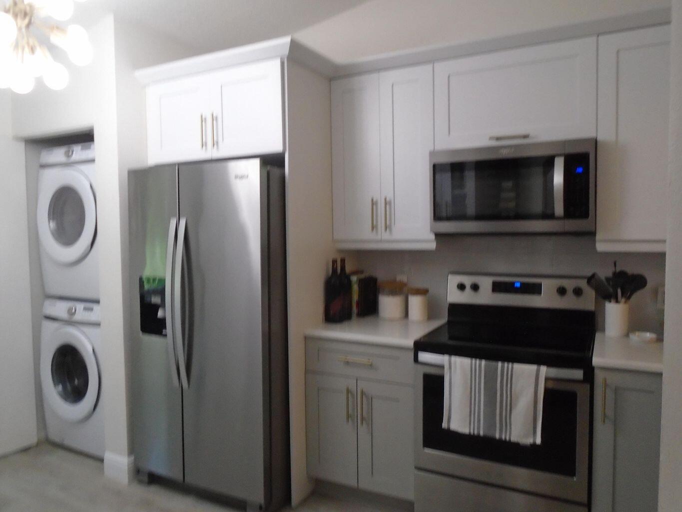 3760 North Jog Road, Unit 204 West Palm Beach, FL 33411 - Photo 16 of 28 a kitchen with white cabinets and stainless steel appliances