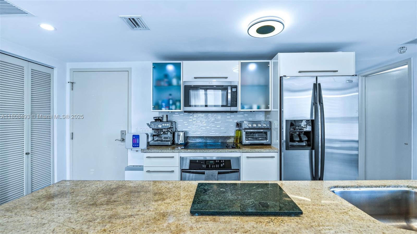 185 Southwest 7th Street, Unit 2911 Miami, FL 33130 - Photo 11 of 33 a kitchen with stainless steel appliances granite countertop a refrigerator and a stove top oven