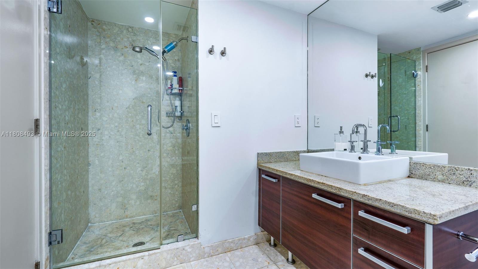 185 Southwest 7th Street, Unit 2911 Miami, FL 33130 - Photo 21 of 33 a bathroom with a granite countertop sink mirror and shower