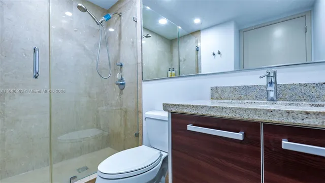 a bathroom with a granite countertop toilet and a sink