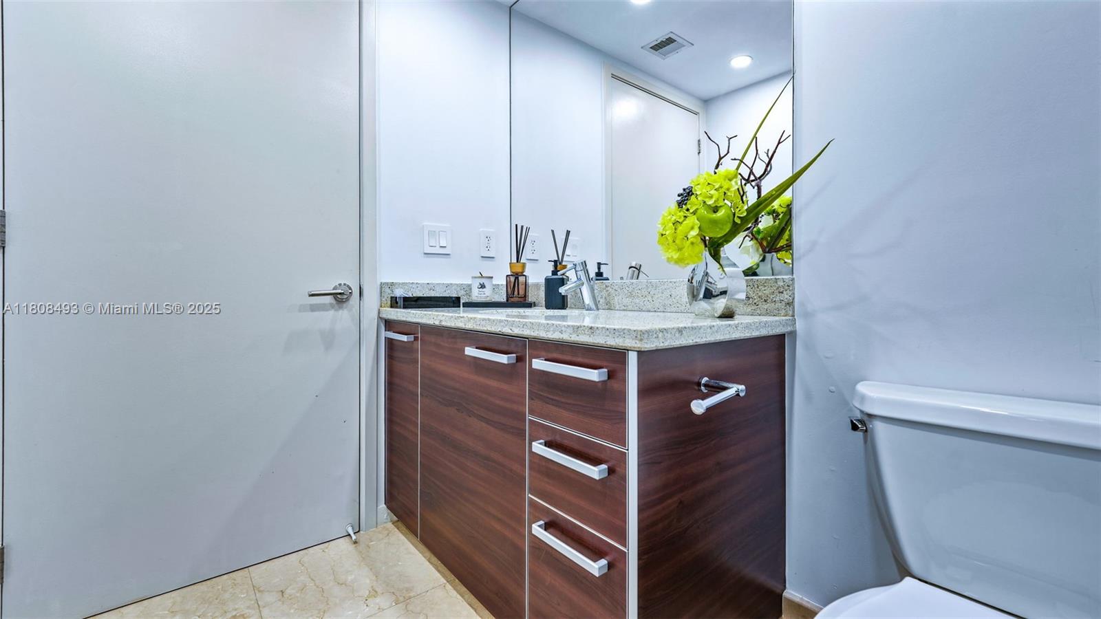 185 Southwest 7th Street, Unit 2911 Miami, FL 33130 - Photo 29 of 33 a bathroom with a sink vanity and a toilet