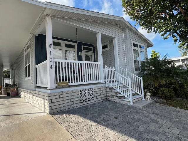 a view of a house with a small yard and wooden floor and fence