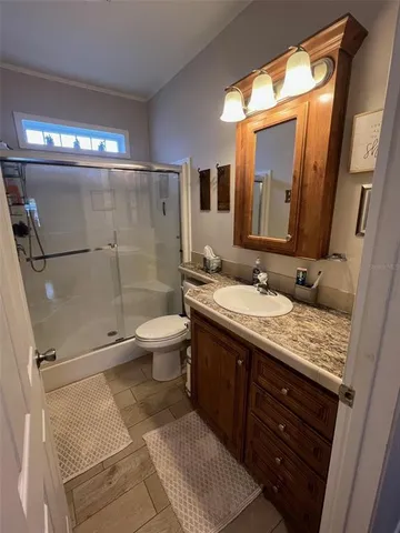 a bathroom with a granite countertop sink toilet and shower