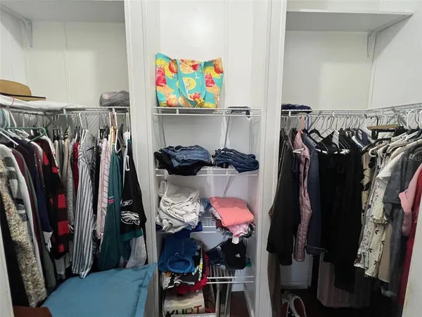 a view of walk in closet with clothes and shoes
