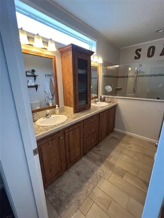 a bathroom with a sink vanity granite tub and shower